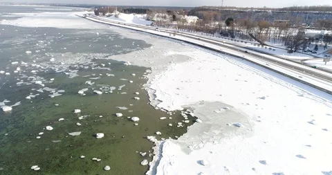 Flying over sandy beach with rolling waves and drifting ice floes in winter sea. Stock Footage 86477047