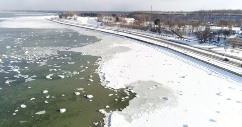 Flying over sandy beach with rolling waves and drifting ice floes in winter sea. Video stock 86477282