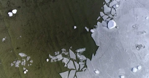 Flying over sandy beach with rolling waves and drifting ice floes in winter Video stock 86477848