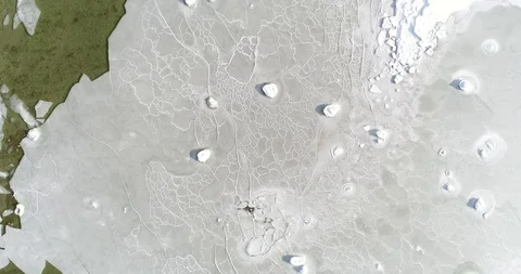 Flying over sandy beach with rolling waves and drifting ice floes in winter sea. Stock Footage 86477853