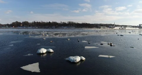 Flying over sandy beach with rolling waves and drifting ice floes in winter sea. Stock Footage 86702355