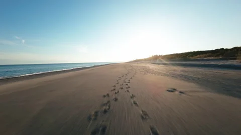 Flying over sandy beach at sunset Stock Footage 261162806