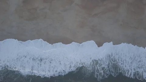 Flying over a sandy beach. Waves break on a sandy beach on the Atlantic coast Stock Footage 129696523