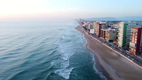 Flying over the sea at the beach next to apartment buildings Stock-Footage 258295903