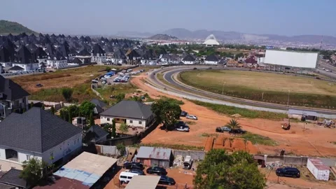 Flying over shacks and a busy highway towards a beautiful suburban neighborhood 動画素材 332816990