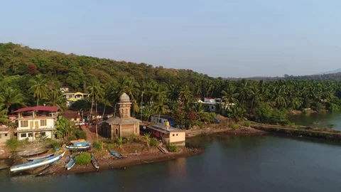 Flying over a small Hindu temple on the shore of the bay. Aerial view. Stock Footage 84974080