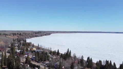 Flying over Small Lake Town Towards Frozen Lake Stock Footage 151721230