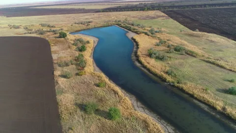Flying over a small pond among the fields Video stock 153009692
