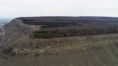 Flying over a small rock with a forest belt Video stock 152985151