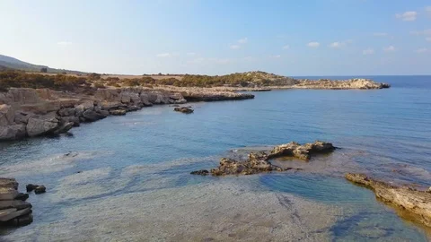 Flying over small stone island in the blue sea Stock Footage 98922973