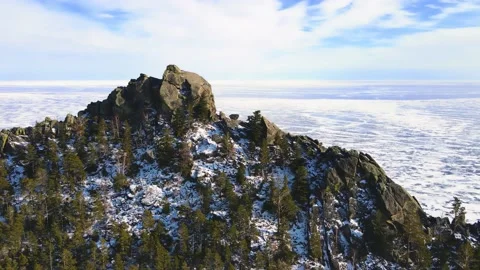 Flying over a snow-covered cliff on the shore of huge lake. Cinematic landscape Stock Footage 172196971