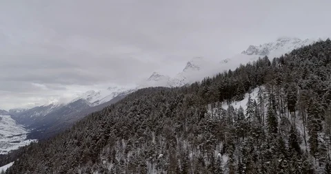 Flying over a snow covered forest in Switzerland. Stockbeeldmateriaal 92936370