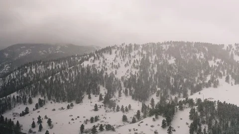 Flying over snow covered mountain in a snow storm. Drone aerial view outside Bou Video stock 124766906