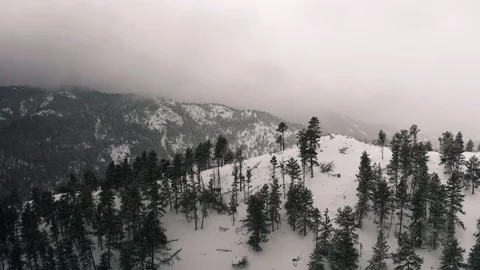 Flying over snow covered mountain in a snow storm. Drone aerial view outside Bou 스톡 동영상 124770321