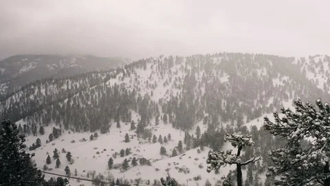 Flying over snow covered mountain in a snow storm. Drone aerial view outside Bou Video stock 124803453