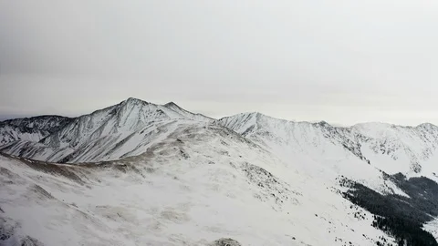 Flying over snow covered mountain after a snow storm. Drone aerial view outside  Video stock 124807530