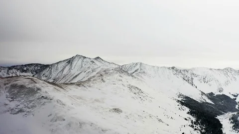 Flying over snow covered mountain after a snow storm. Drone aerial view outside  Video stock 124807721