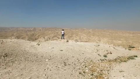Flying over standing man at the edge of Wadi Qelt canyon. Israel. DJI-0194-08 Stock Footage 124444783