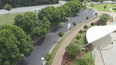 Flying over street lined with trees on both side to busy street Stock Footage 171135129