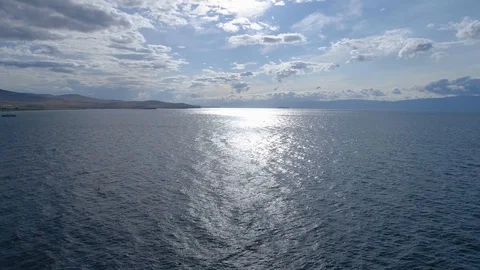 Flying over the surface of the blue water and the shore of lake Baikal Stock Footage 121926246