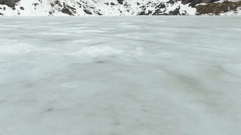 Flying Over the Surface of a Frozen Lake Slowly Tilting Upwards In Lofoten Stock Footage 116393096