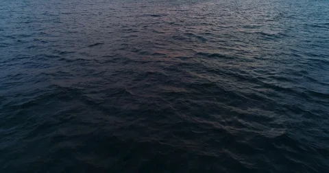 Flying over the surface of the water towards the sun at sunset. Stock Footage 107435471