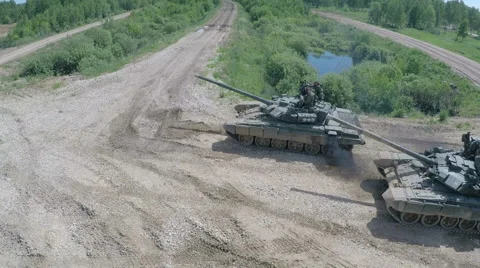 Flying over tank driving on rough ground in the woods Stock Footage 63071006