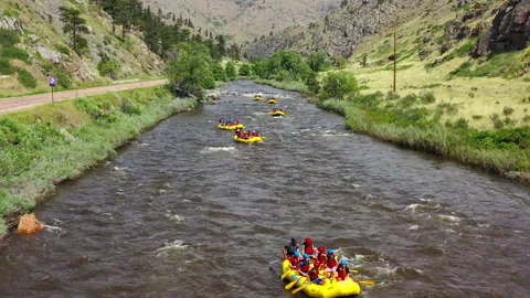 Flying over teams of rafters riding down the Poudre River Stock Footage 247363887