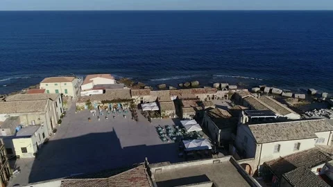 Flying over the tile roofs that surround the marina in Marzamemi, Sicily Stock Footage 179368124