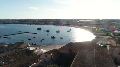 Flying over the tile roofs that surround the marina in Marzamemi, Sicily Stock Footage 179368195