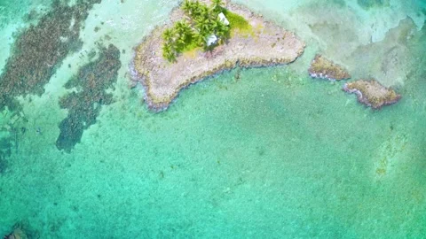 Flying Over Tiny Tropical Island in Clear Blue Caribbean Water Stock Footage 148883875