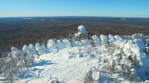 Flying over the top of the mountain approaching a lonely rock in winter day 스톡 동영상 61156131