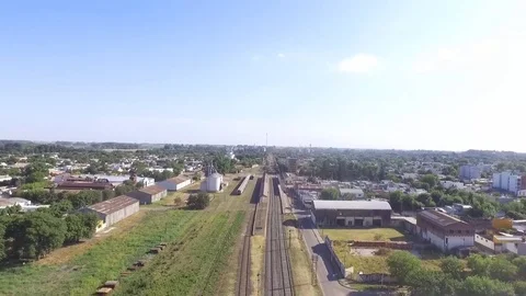 Flying over the tracks of an old train station in a very small city. Video stock 85027749