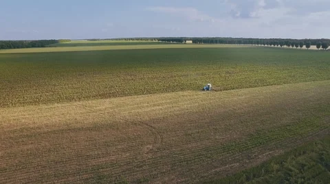 Flying over a tractor plowing a field Stock Footage 64237122