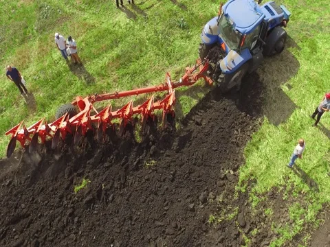 Flying Over Tractor Plowing Ground Stock Footage 73716988