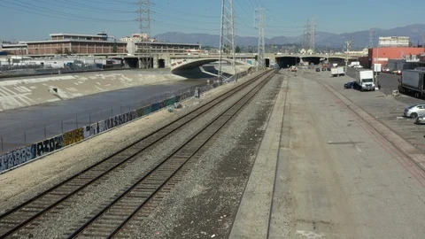 Flying over train tracks next to the Los Angeles river in an industrial area of Video stock 102590633