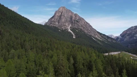 Flying over trees towards mountain in the Dolomites Stock Footage 220378782