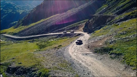 Flying over trucks on mountain trail Vídeo Stock 87621791