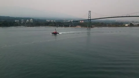 Flying over tug boat with a view of Vancouver's Lions Gate bridge 動画素材 248481834