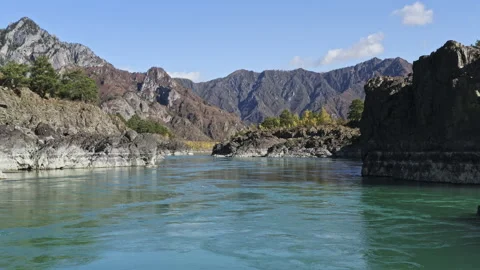 Flying over turquoise surface of mountain river with rocky shores Stock Footage 194379211