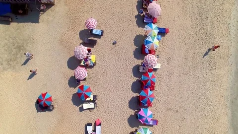 Flying over umbrellas on the beach Stock Footage 83220634