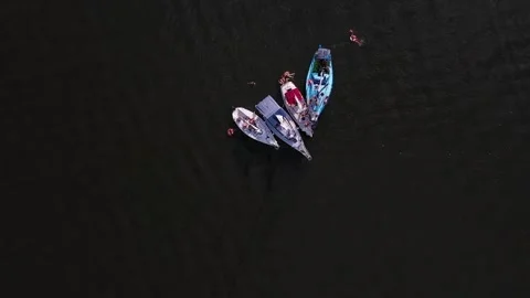 Flying over unrecognizable people rest on aboard sailboats at calm lake Stock Footage 300850693