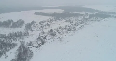 Flying over the village, with active snowfall Stock Footage 147697445
