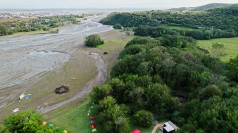 Flying over a village in Georgia, camera tilt down to camping base. cloudy Stock Footage 252173975