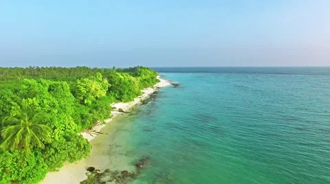 Flying over water, stone and sand beach in the Maldives. Video stock 62066837