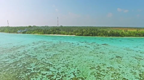 Flying over water, stone and sand beach in the Maldives. Video stock 62067553