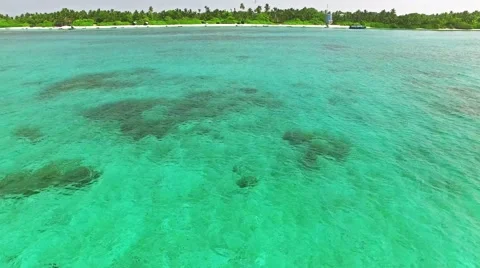 Flying over water, stone and sand beach in the Maldives. 動画素材 62068421