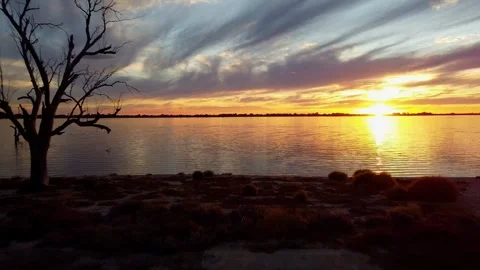Flying over water into the sunset Stock Footage 307729746
