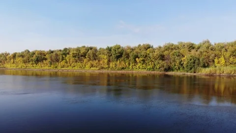 Flying over the water surface to the autumn forest Stock Footage 123104199