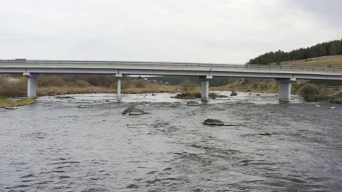 Flying over the water under a road bridge Stock Footage 134006398